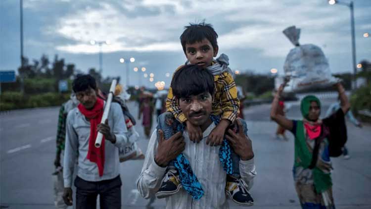 Dayaram Kushwaha, a migrant worker, carries his 5-year-old son, Shivam, on his shoulders as they walk along a road to return to their village, during a 21-day nationwide lockdown to limit the spread of coronavirus, in New Delhi in 2020